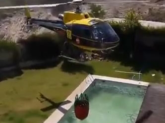 Çılgın helikopter pilotu, yüzme havuzundan su alıyor